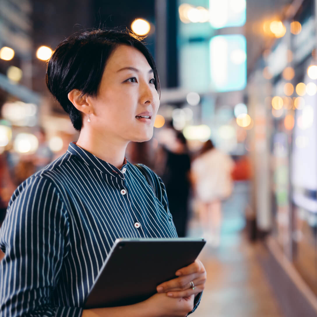  woman holding tablet in downtown area
