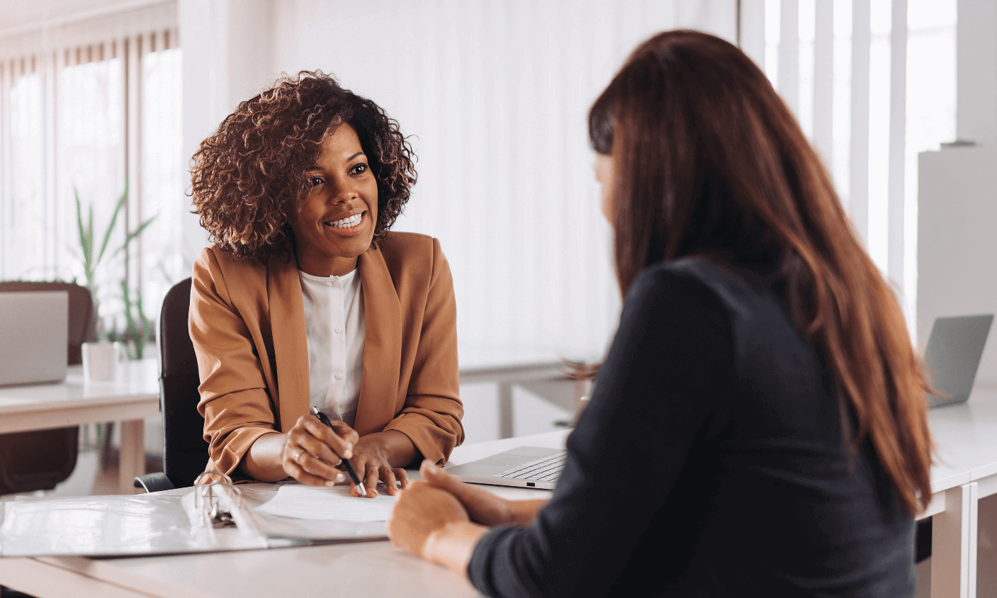 financial advisor sitting at desk with and talking to client