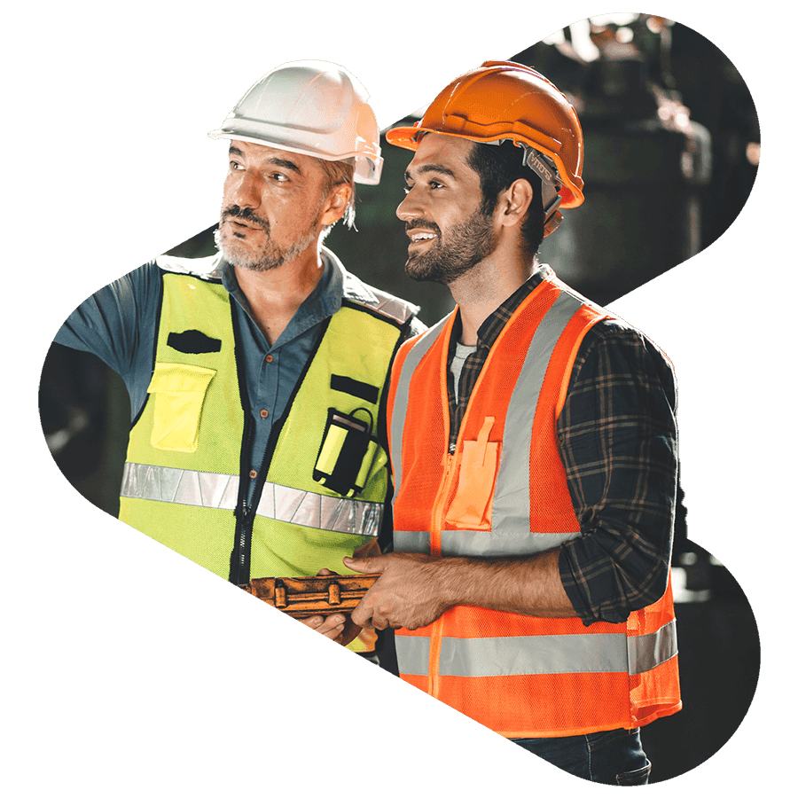 manufacturing workers wearing orange and yellow vest and hard hats