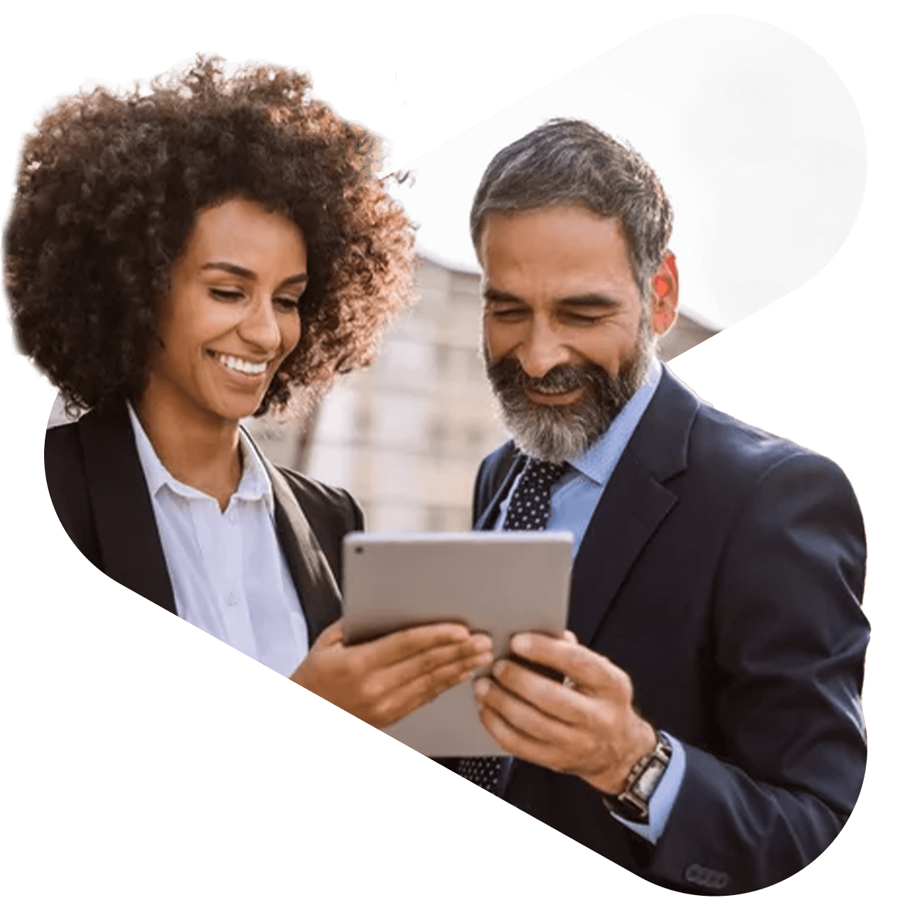 two coworkers both holding and looking at a tablet