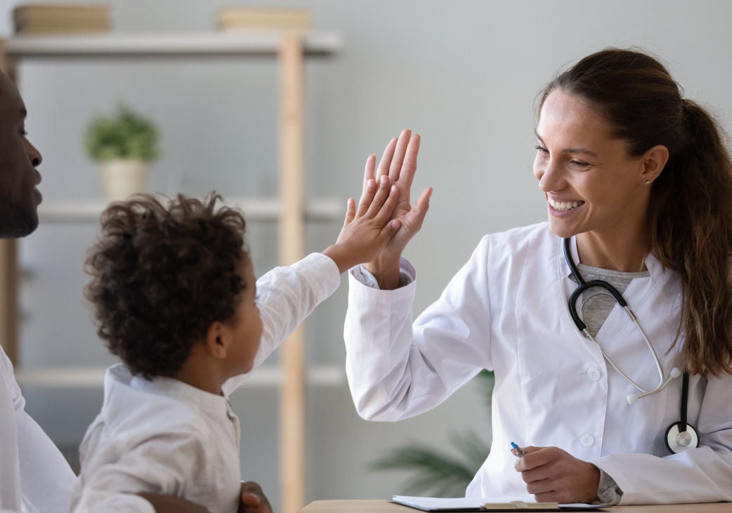 a woman doctor hi fiving a toddler