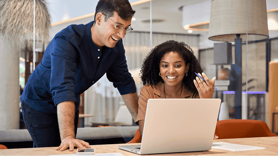 Two coworkers looking at a computer togehter