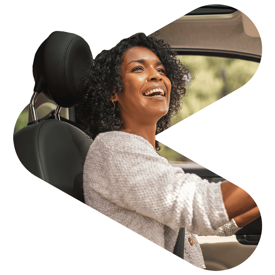 woman smiling while driving a car