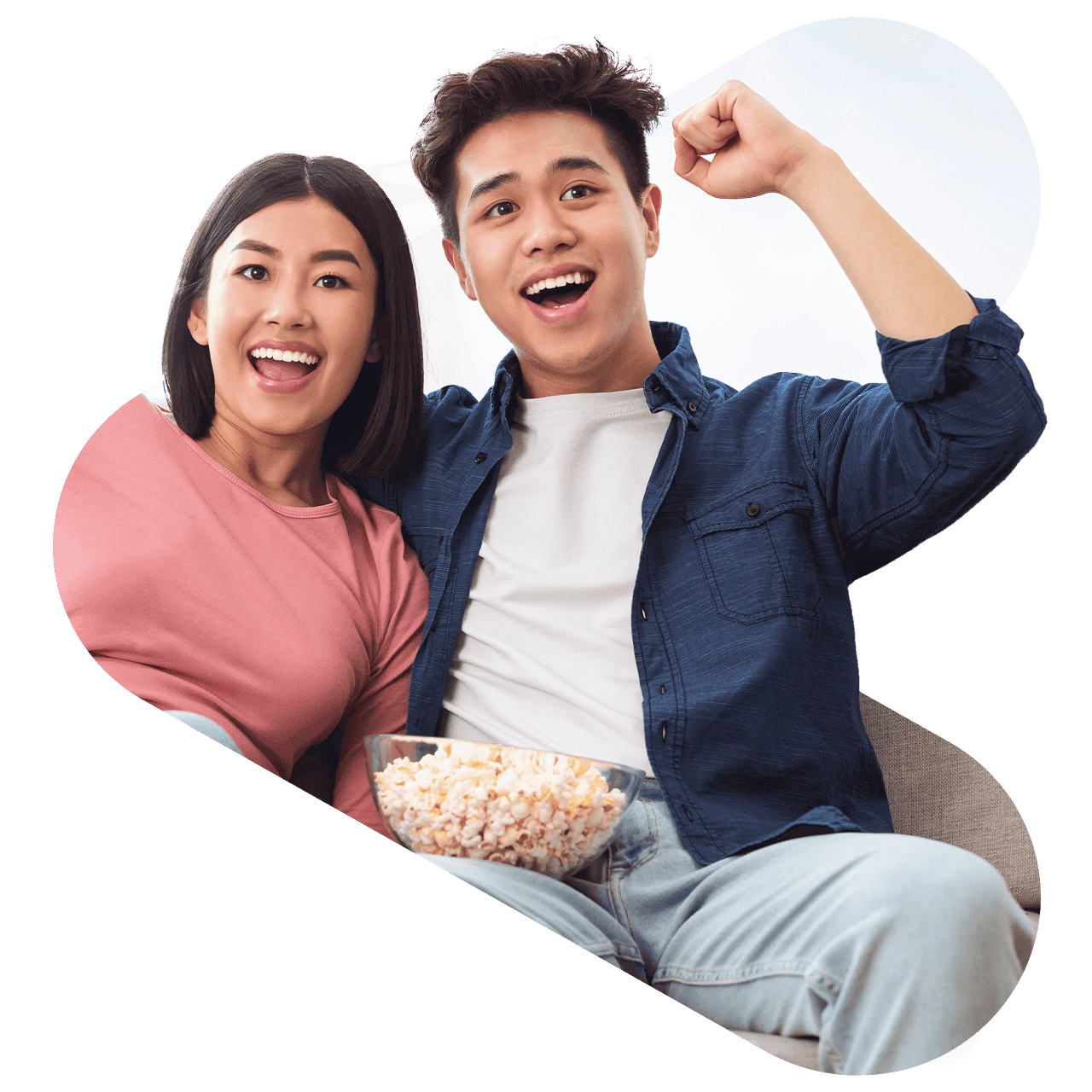two fans sitting on a couch cheering for a game
