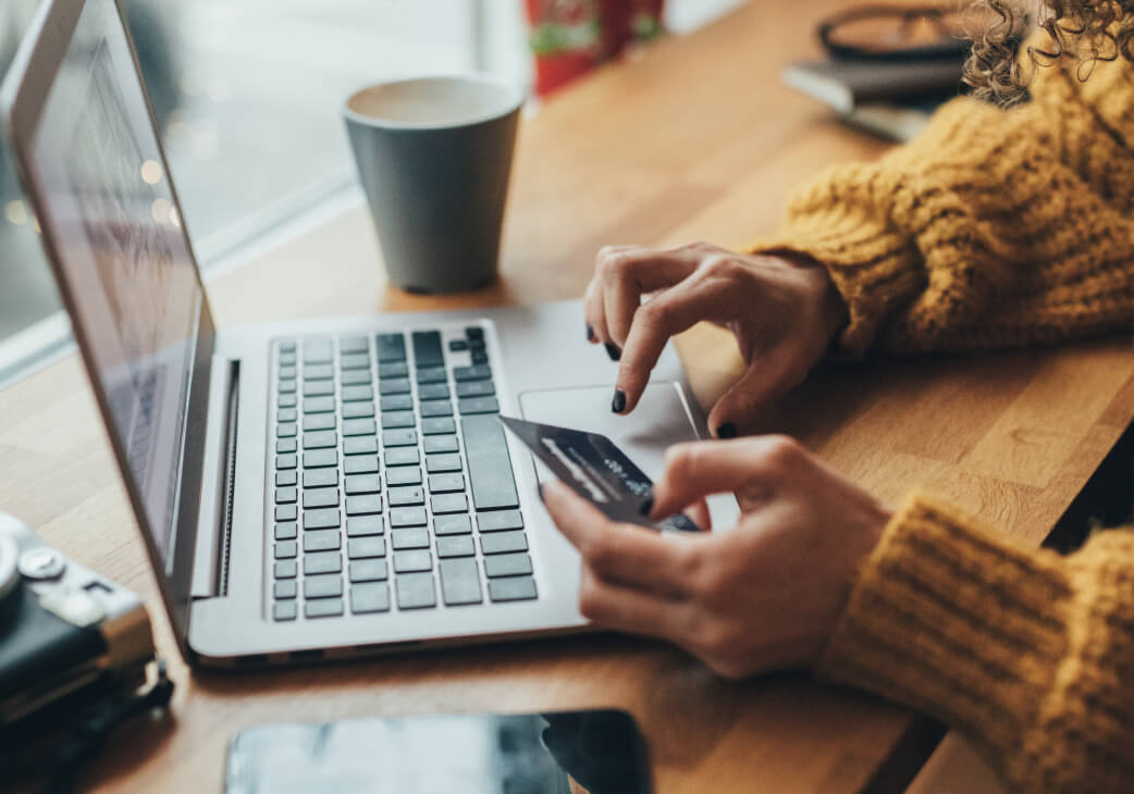 A woman typing on the computer her credit card details