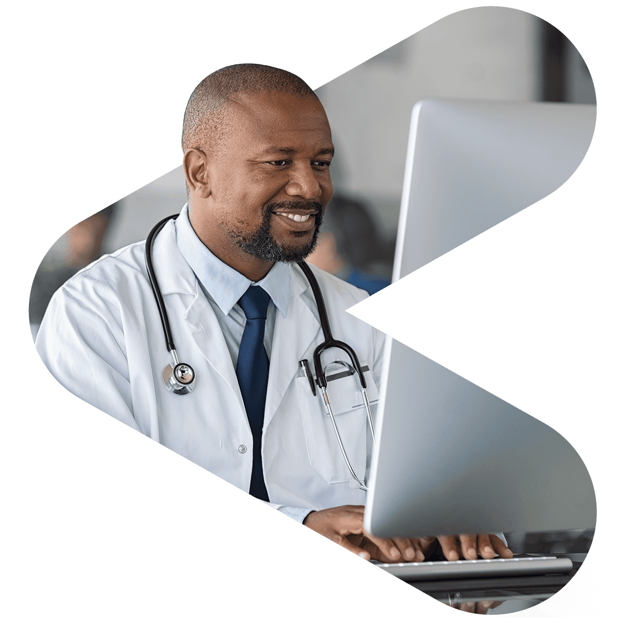 Doctor smiling and working at a desktop computer