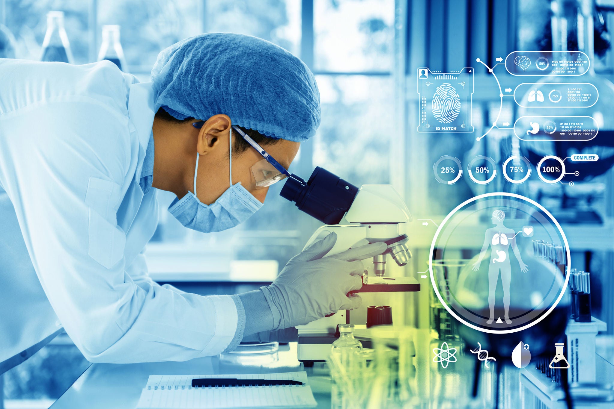 Masked male doctor looking into a microscope