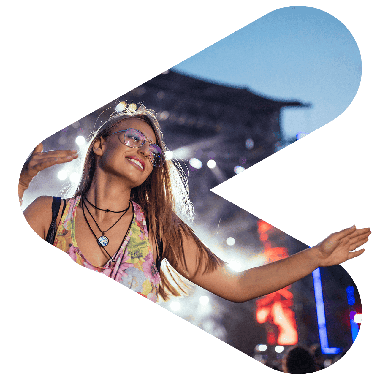 woman at festival dancing with stage and lights behind her