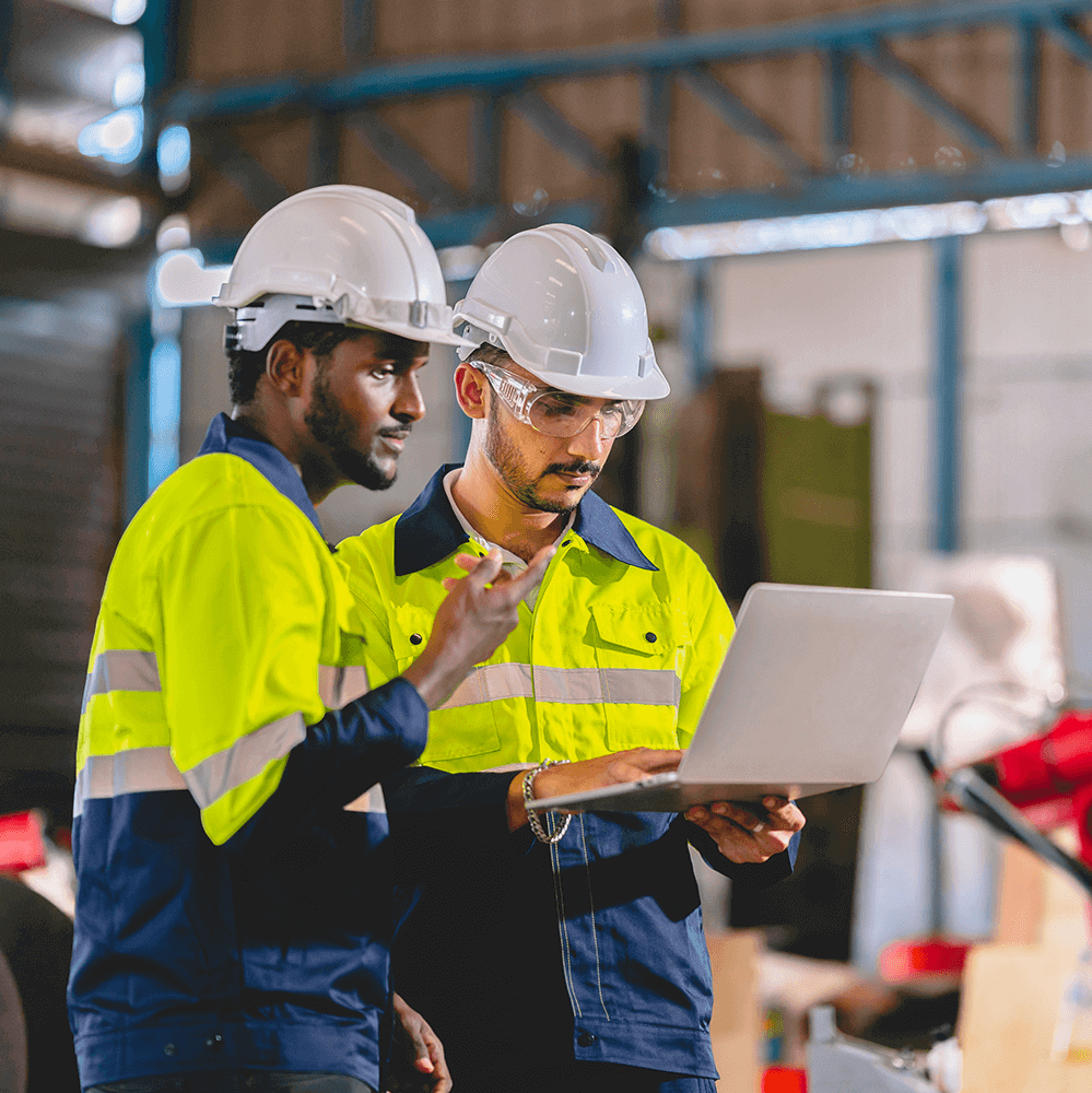 two manufacturing employee working together on laptop