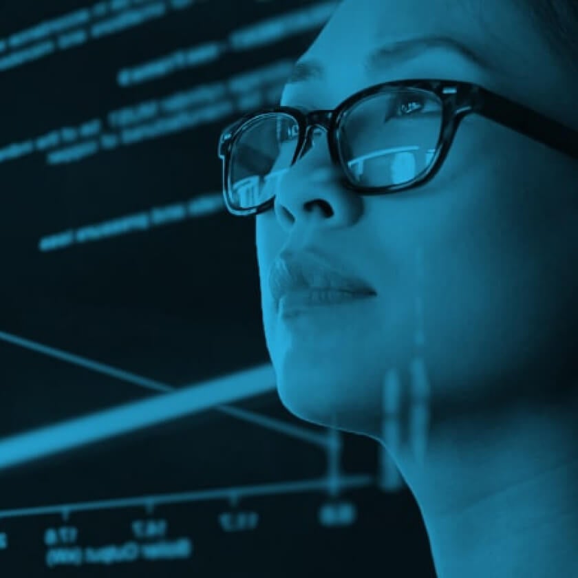 woman looking at screen that is reflecting on her face