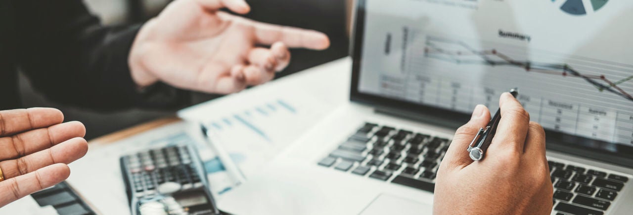 two workers reviewing data on laptop