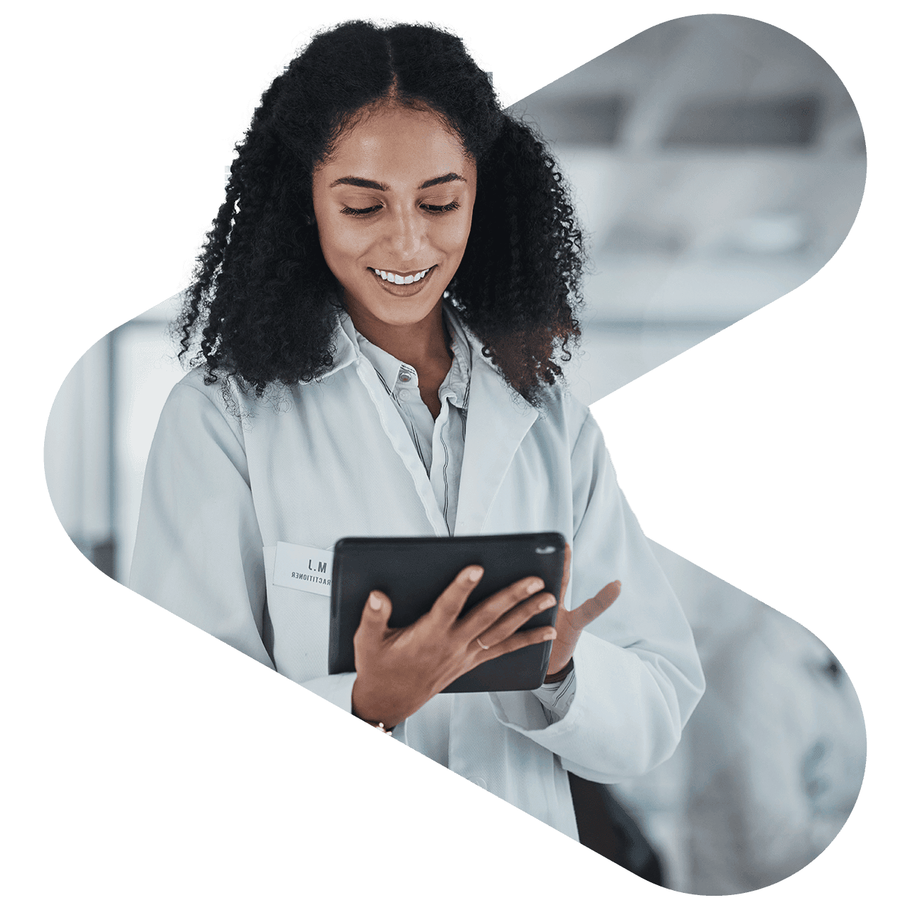 a doctor smiling while looking down and holding an ipad