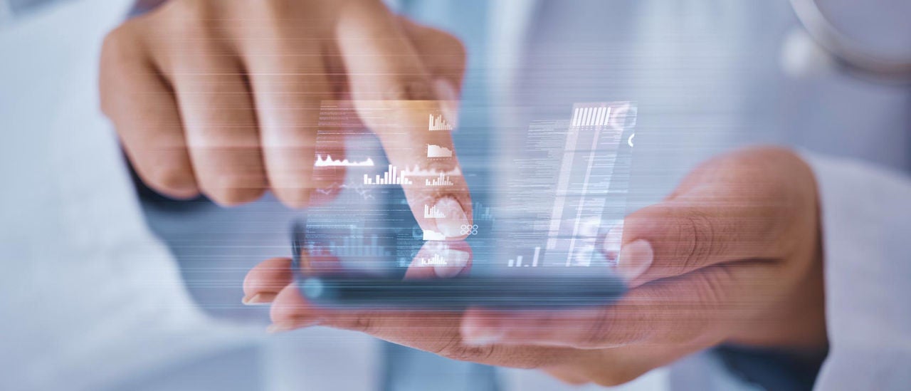 Close up of a doctor's hands, holding her phone and tapping the screen
