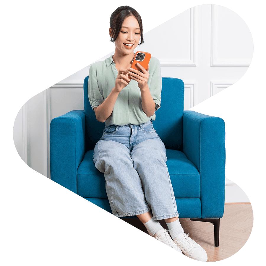 korean woman sitting on a blue couch using her phone