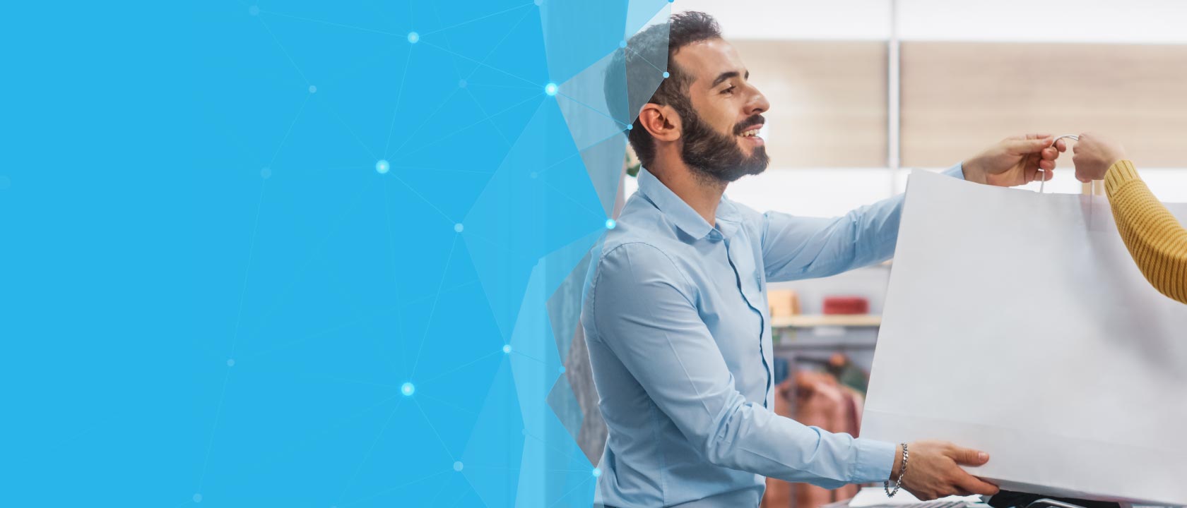 Smiling man handing off shopping bag to another person