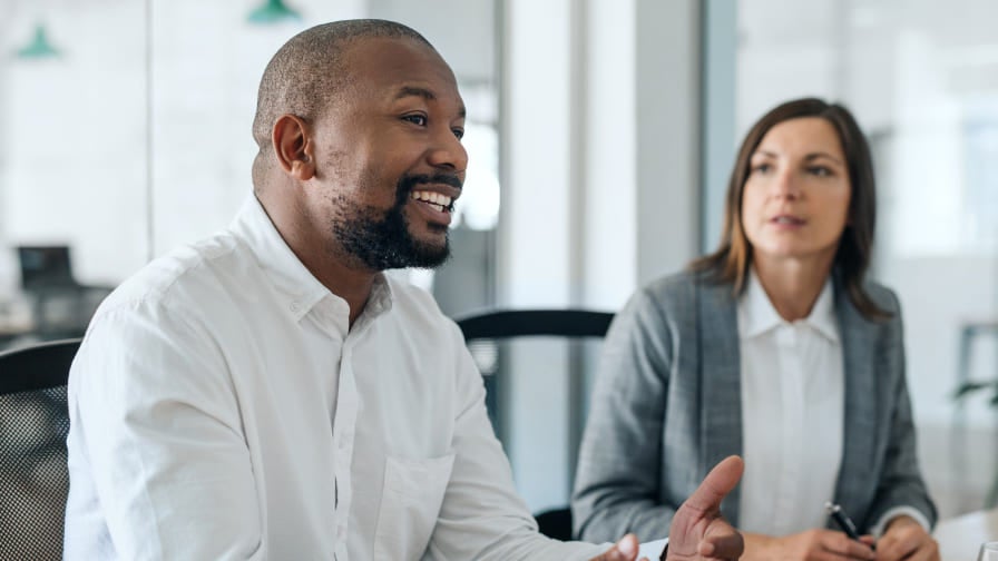 Business man and woman sitting together at conference table