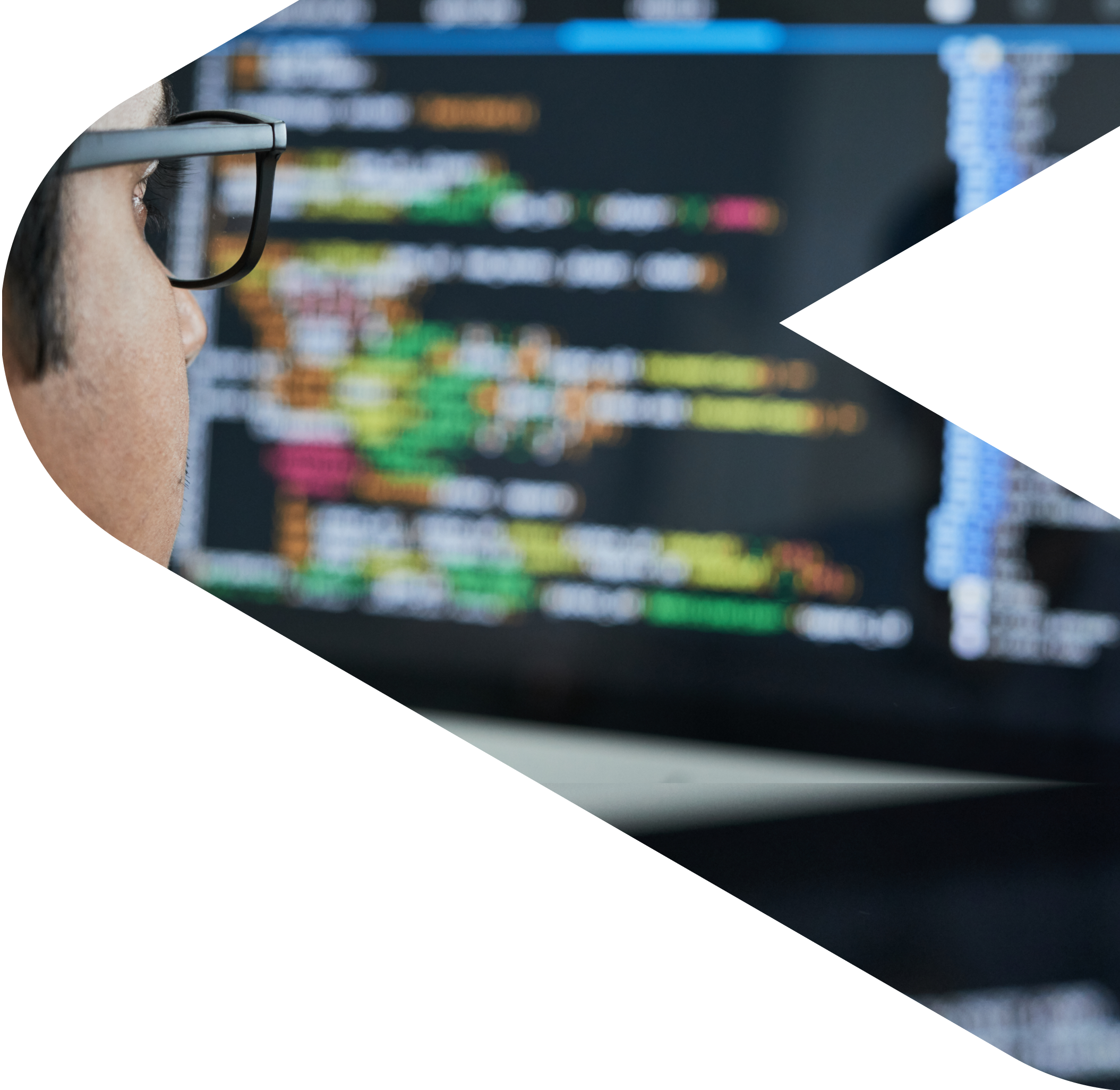 A guy with glasses looks at a screen with blurry code